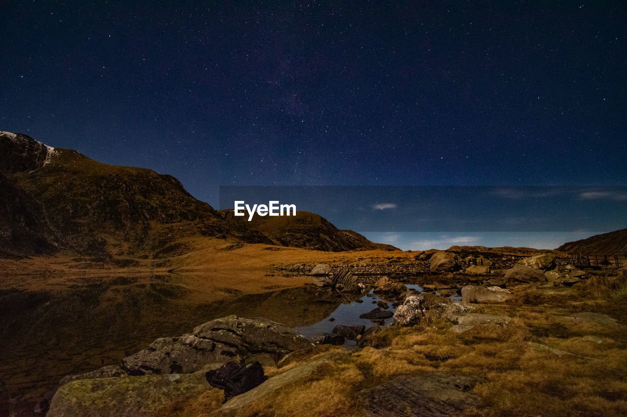 Scenic view of mountains against sky at night