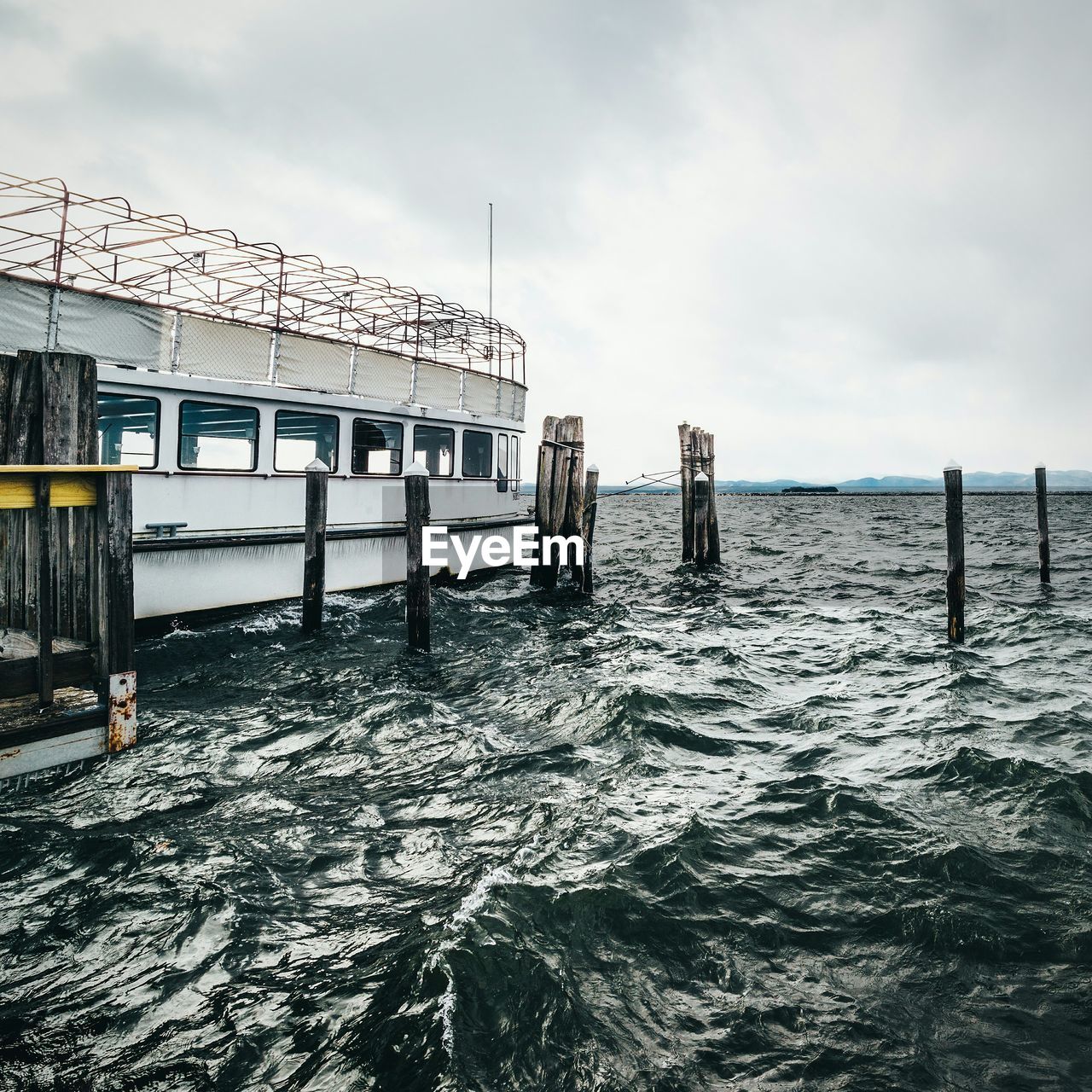 Ferry boat moored on sea against sky