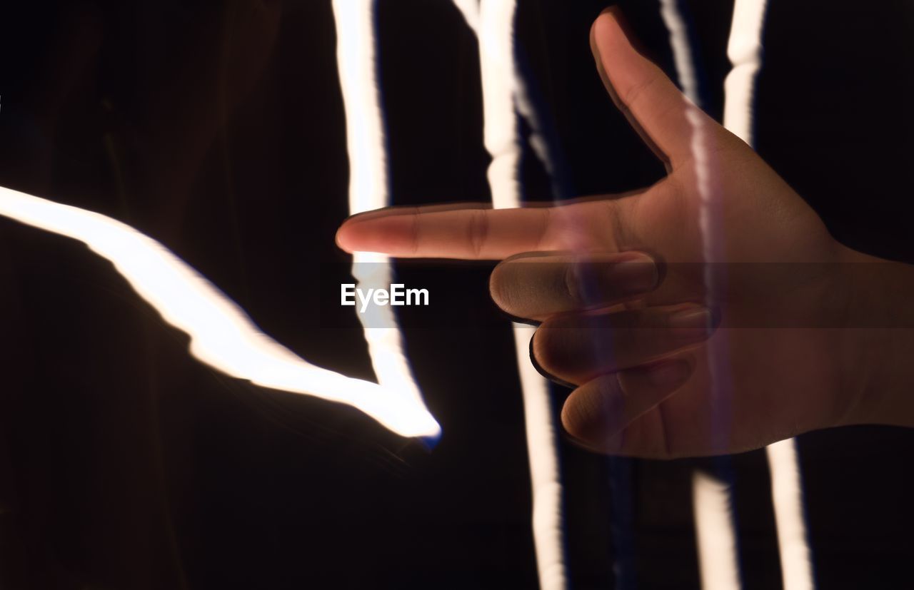 hand, finger, indoors, one person, adult, close-up, limb, arm, light, human limb, studio shot, black background, performance art