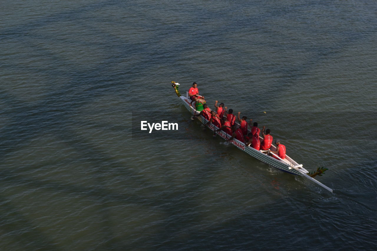 High angle view of people sitting on rowboat in river