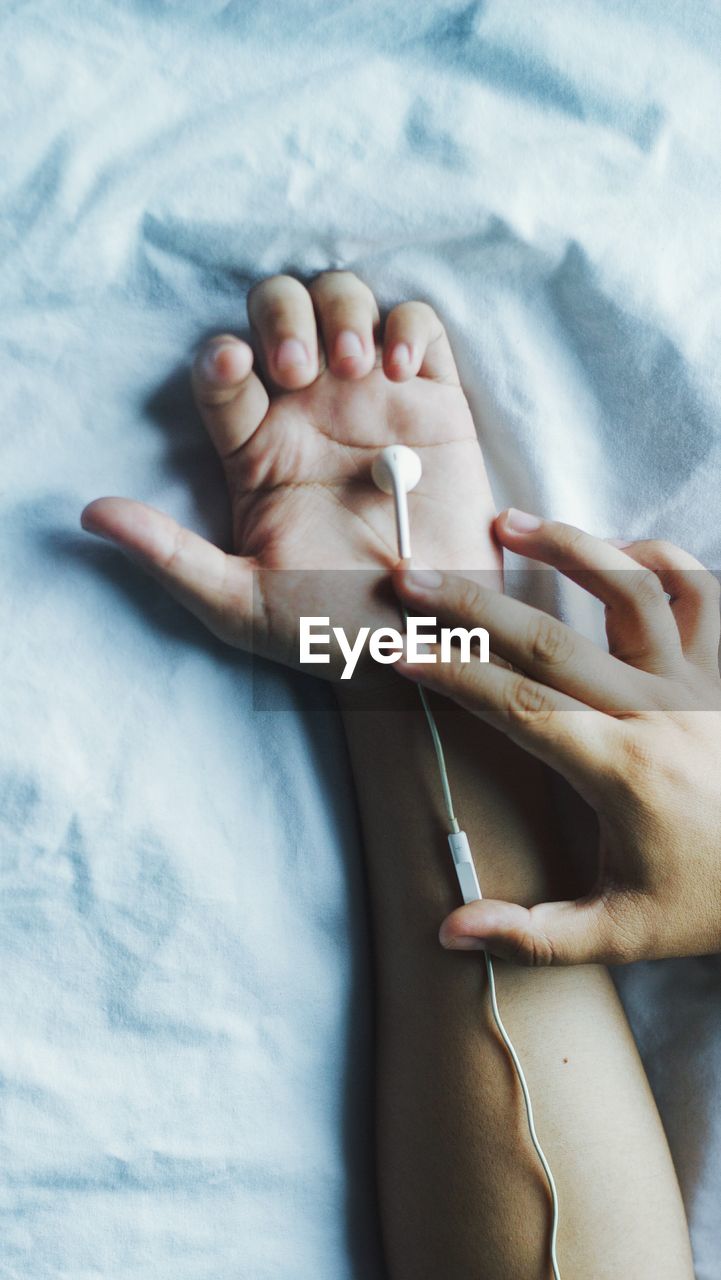 Close-up of in-ear headphones on hand