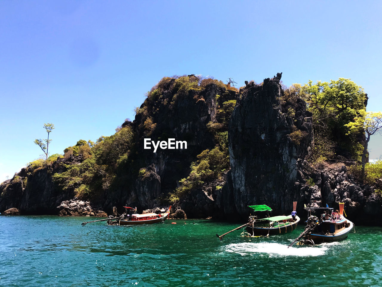 Scenic view of rocks in sea against clear sky