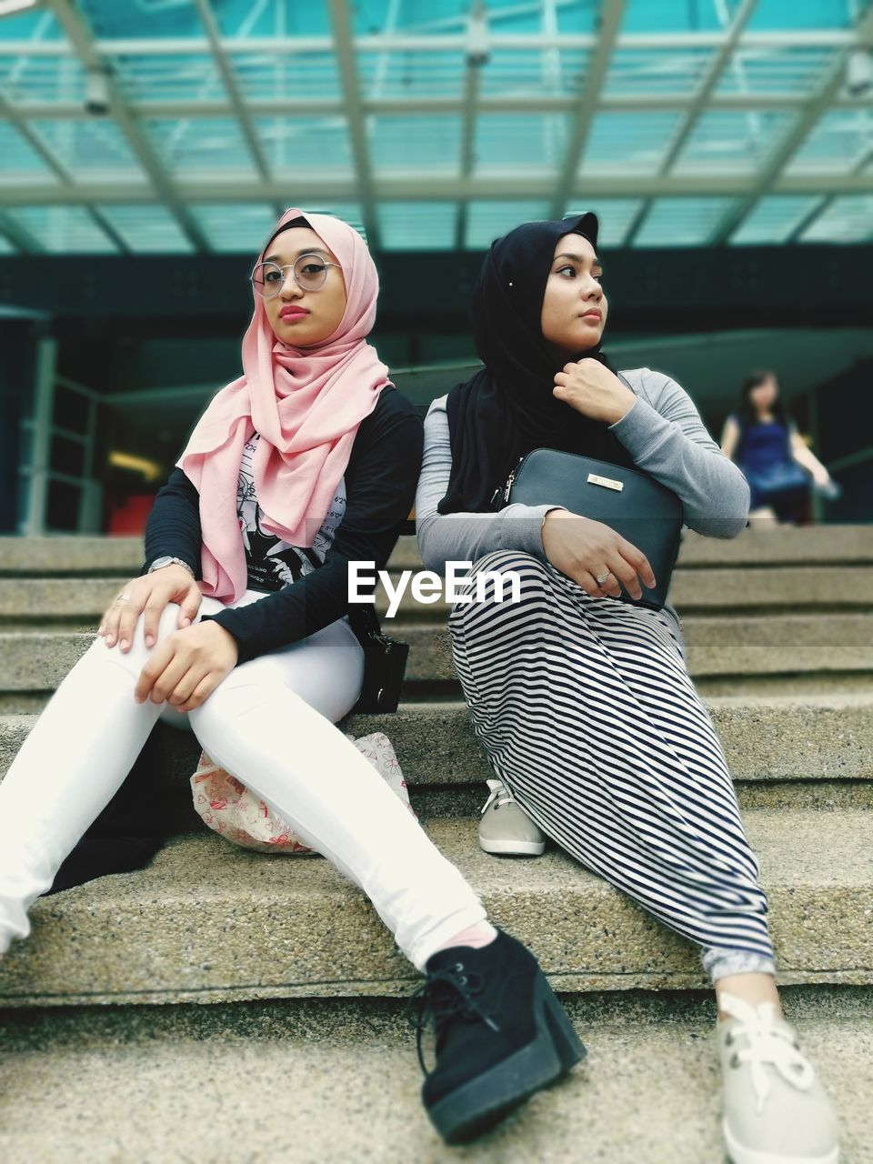 Full length of young women sitting on steps