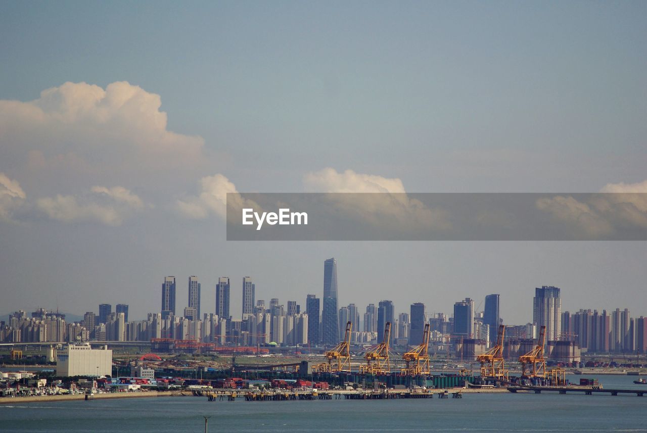 VIEW OF CITYSCAPE BY SEA AGAINST SKY