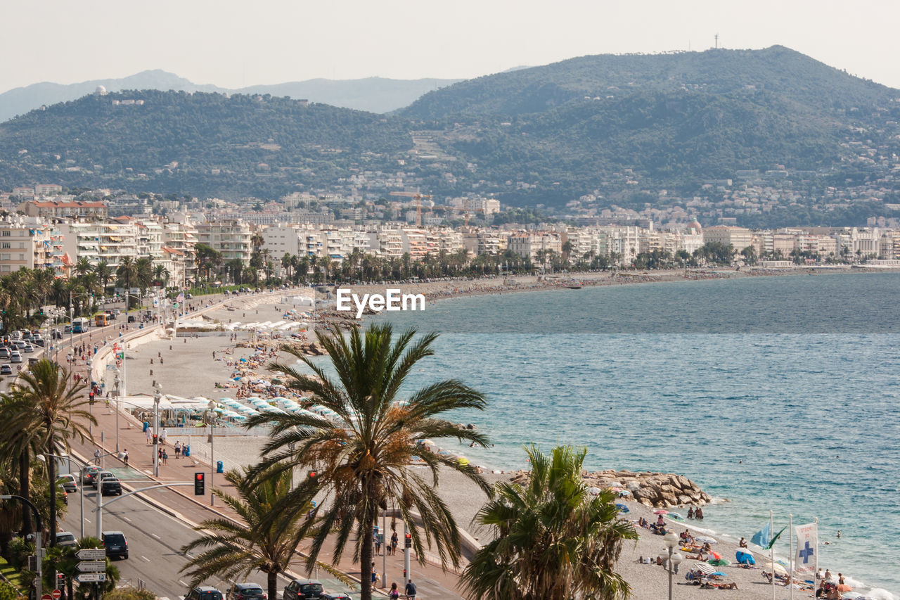 HIGH ANGLE VIEW OF PALM TREES BY SEA AGAINST SKY