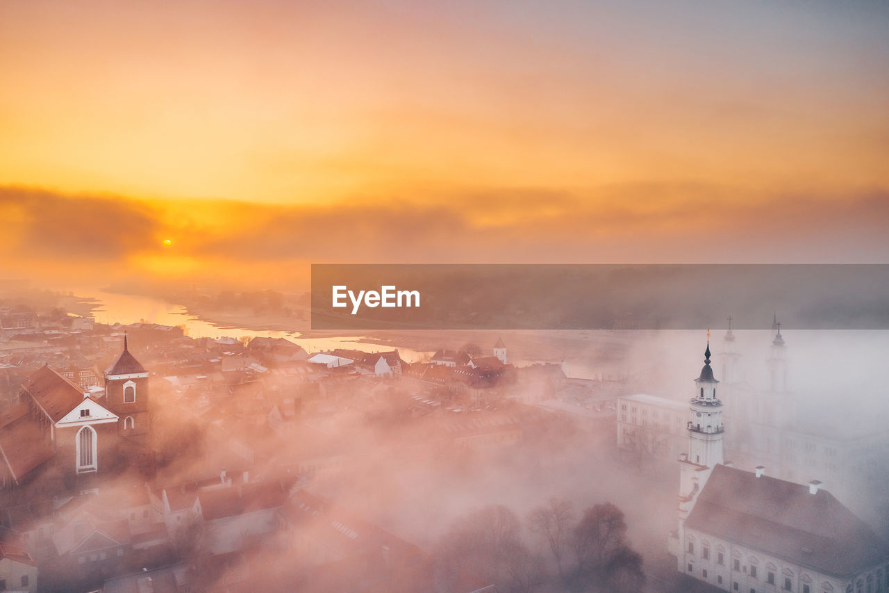 AERIAL VIEW OF BUILDINGS IN CITY AT SUNSET