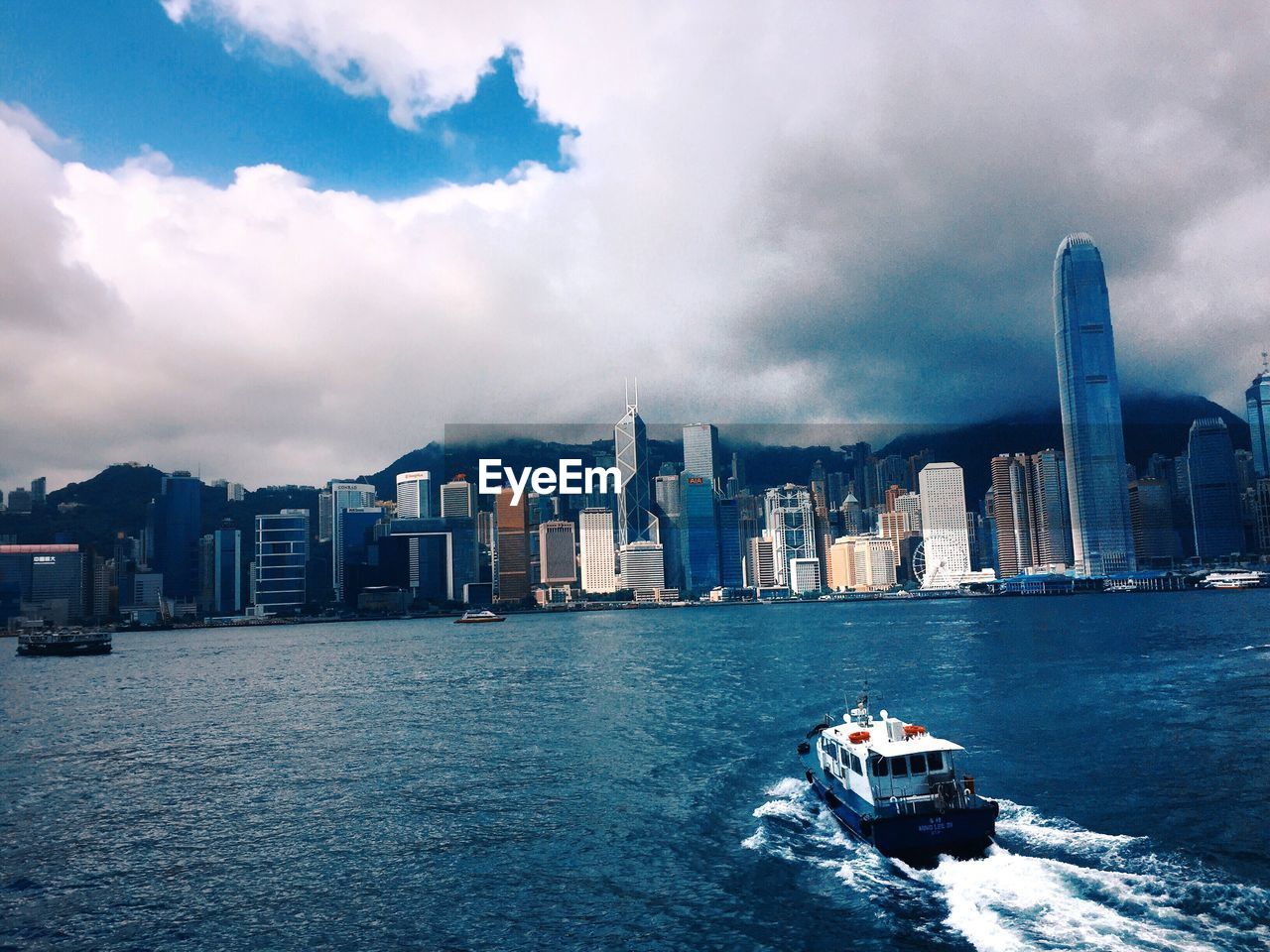 Boat sailing in sea against sky in city