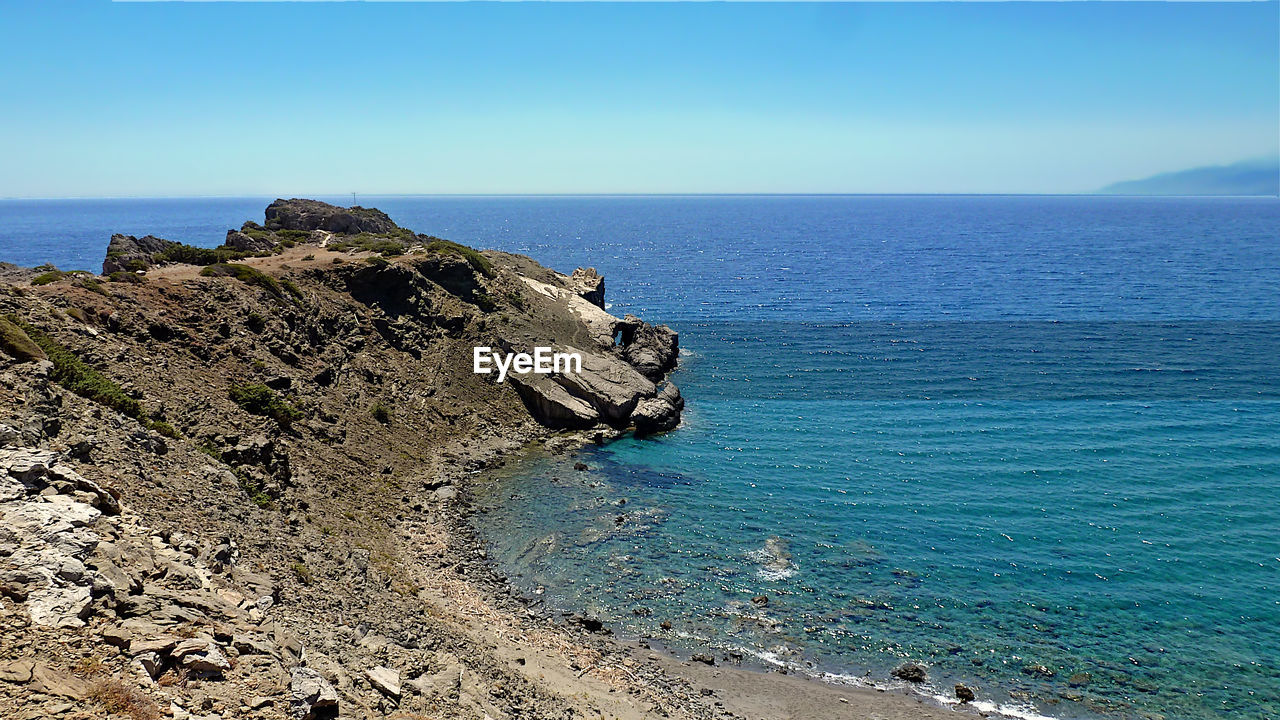 sea, water, scenics - nature, sky, land, beauty in nature, horizon over water, horizon, beach, nature, ocean, tranquil scene, cliff, tranquility, rock, coast, shore, blue, day, terrain, clear sky, islet, body of water, cove, bay, idyllic, no people, rock formation, non-urban scene, outdoors, tower, vacation, coastline, travel destinations, promontory, sunlight, travel, high angle view