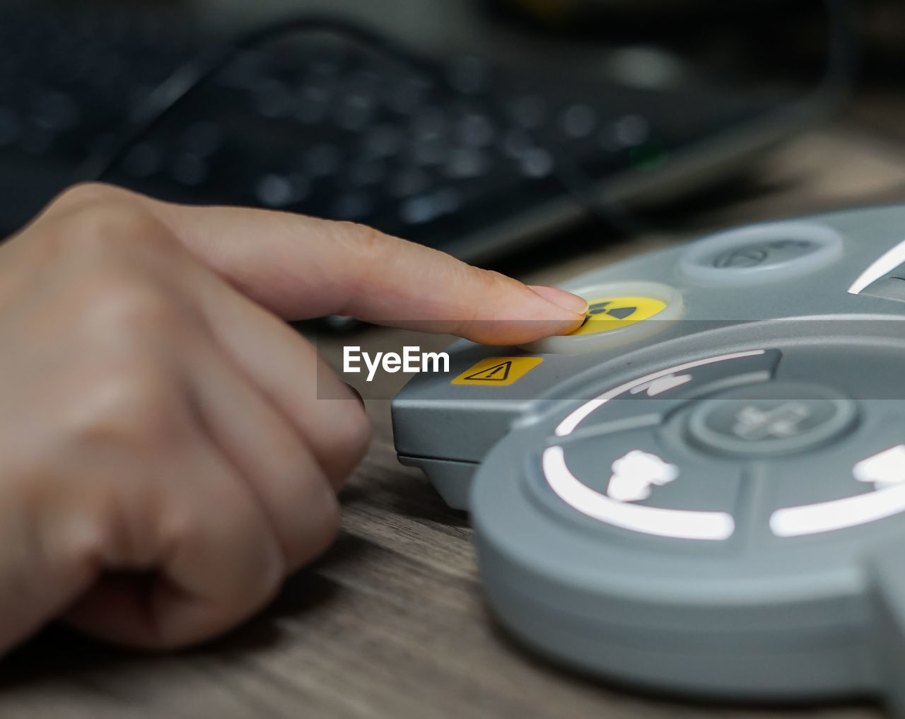 Cropped image of person pressing medical equipment button on table