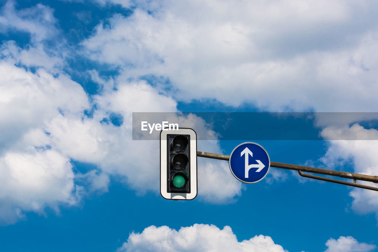 Low angle view of road signal against cloudy blue sky