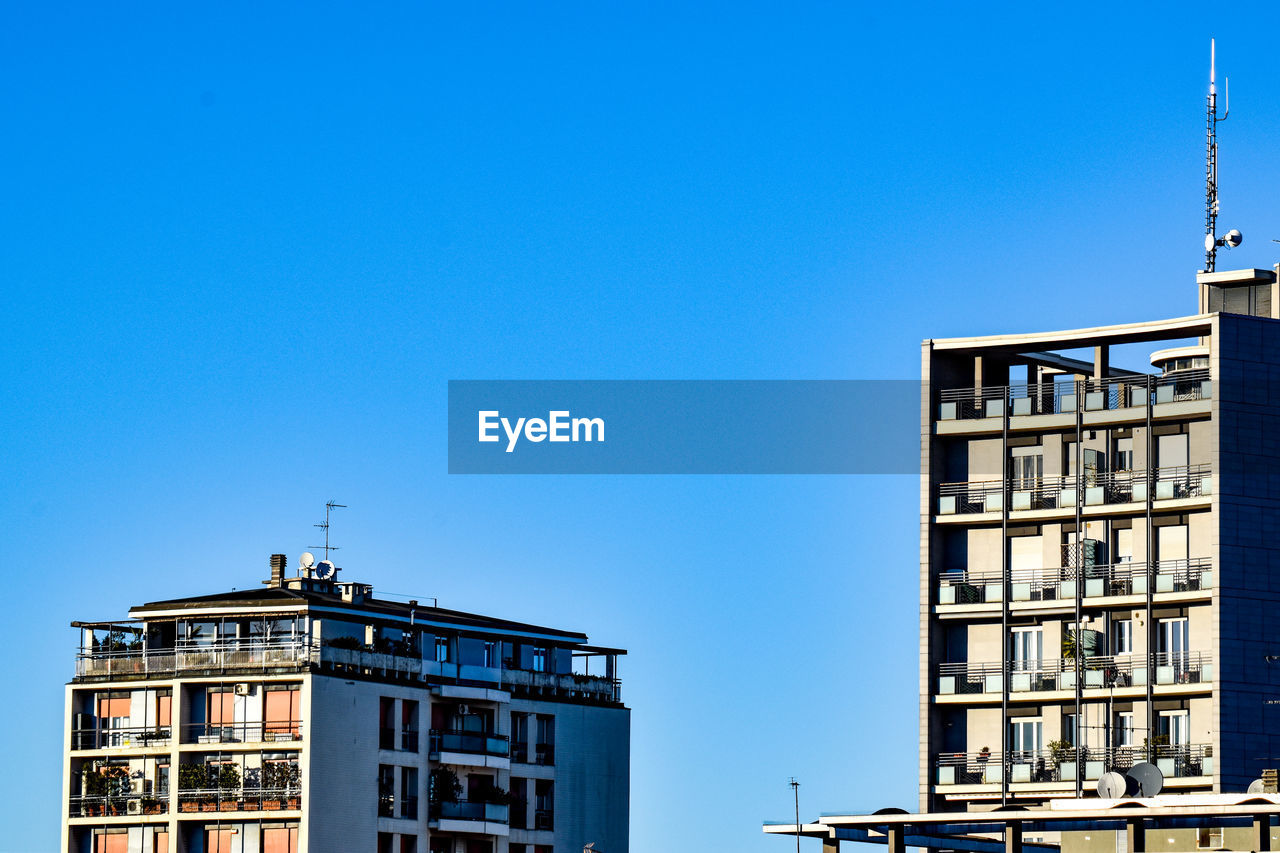 LOW ANGLE VIEW OF BUILDING AGAINST BLUE SKY