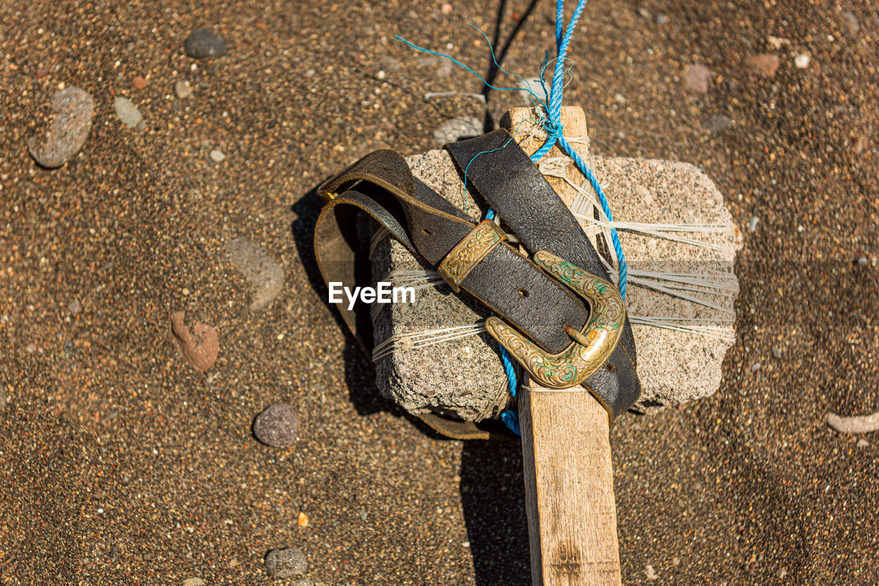 HIGH ANGLE VIEW OF SHOES HANGING ON LAND