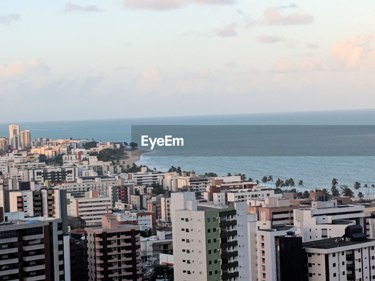 HIGH ANGLE VIEW OF SEA BY BUILDINGS IN CITY