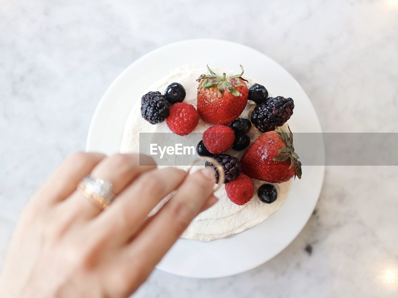 HIGH ANGLE VIEW OF HAND HOLDING STRAWBERRY