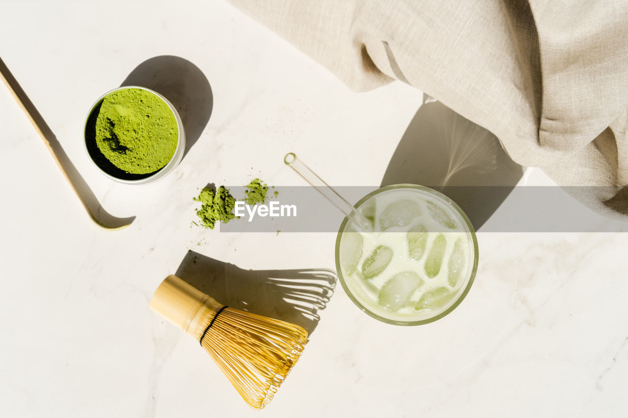 HIGH ANGLE VIEW OF PERSON HAVING COFFEE ON TABLE