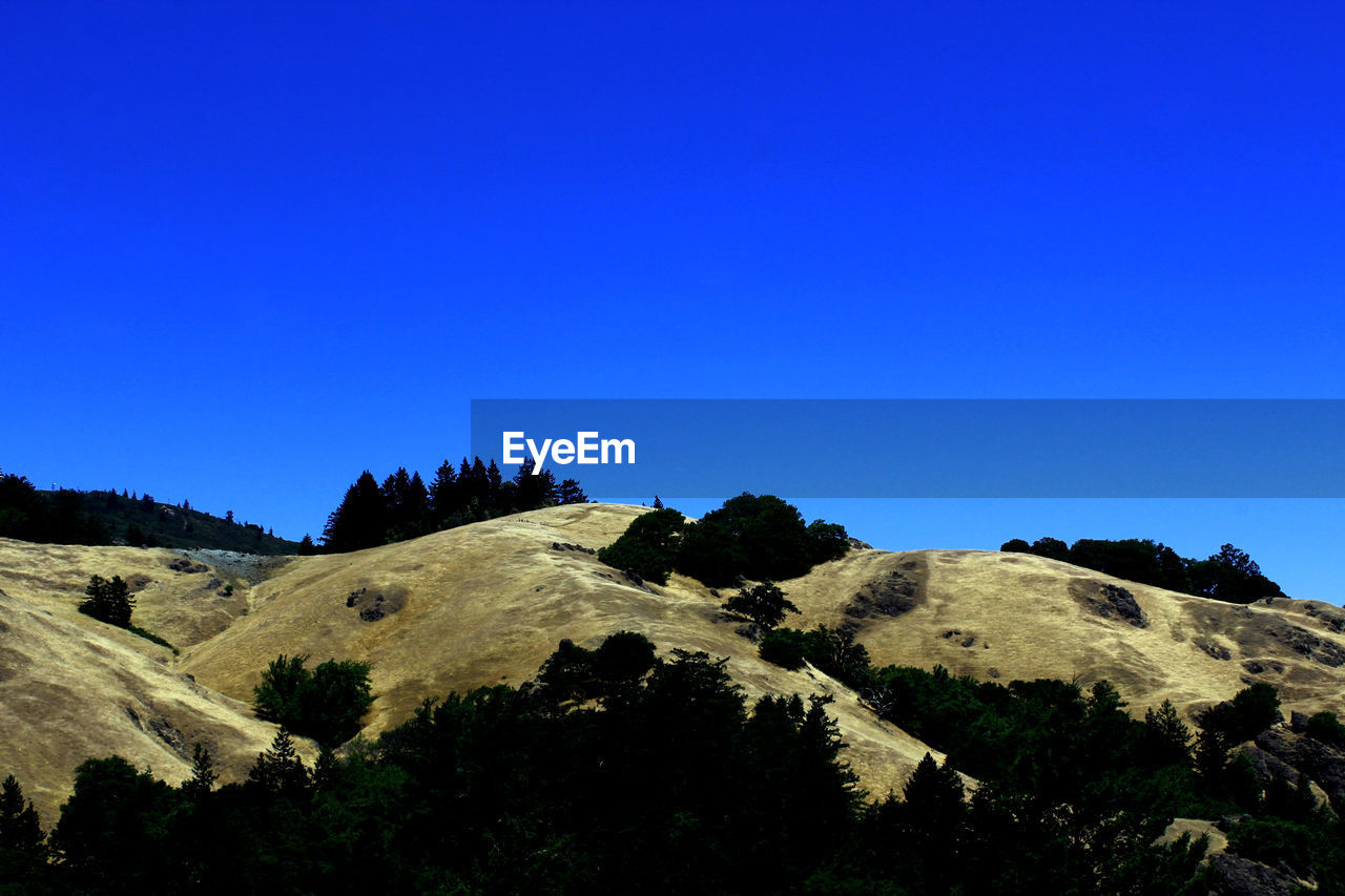 Scenic view of mountains against clear blue sky