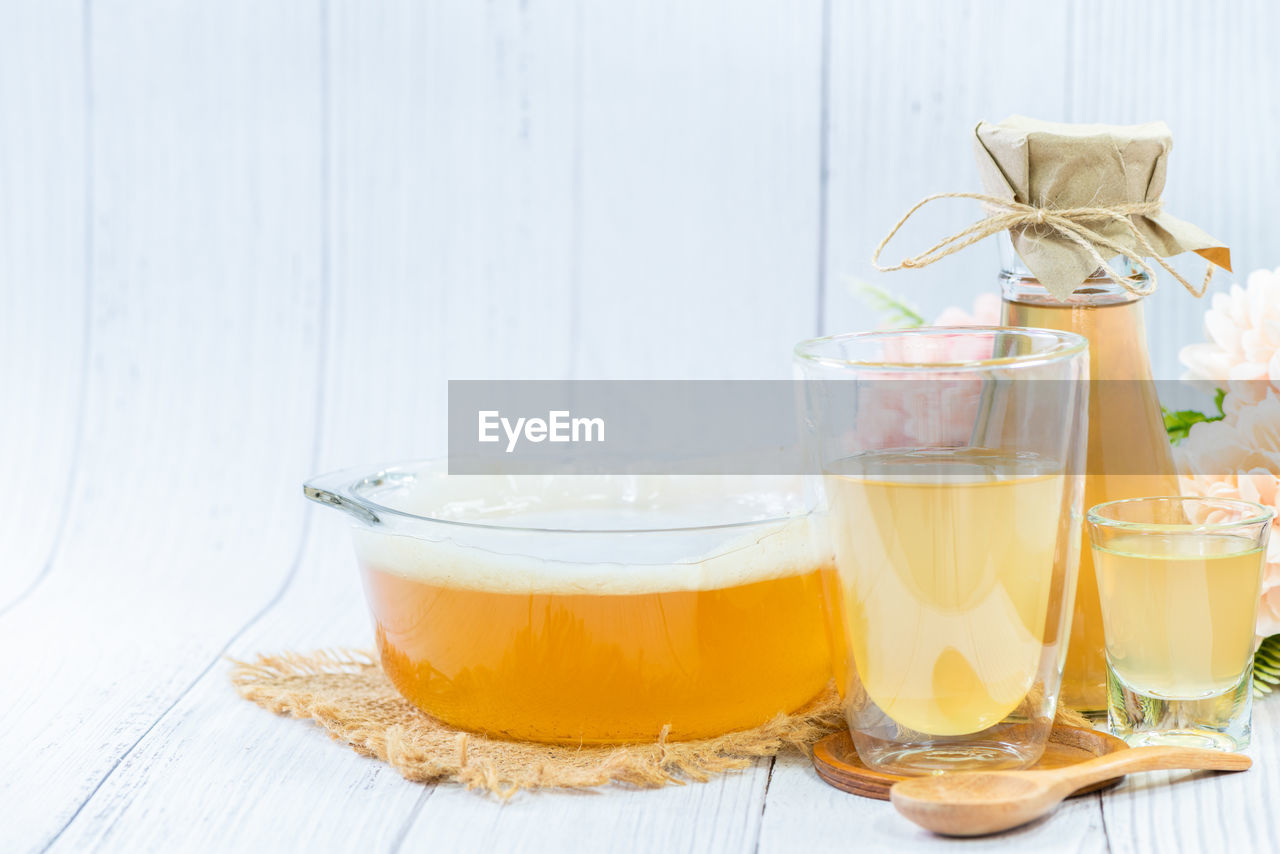 Scoby and kombucha tea in bowl glass on wood background,