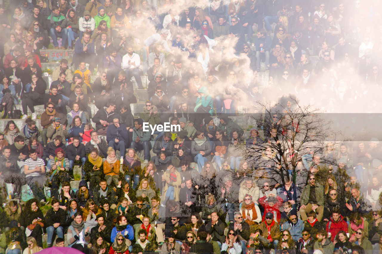 Double exposure of people and cloudy sky