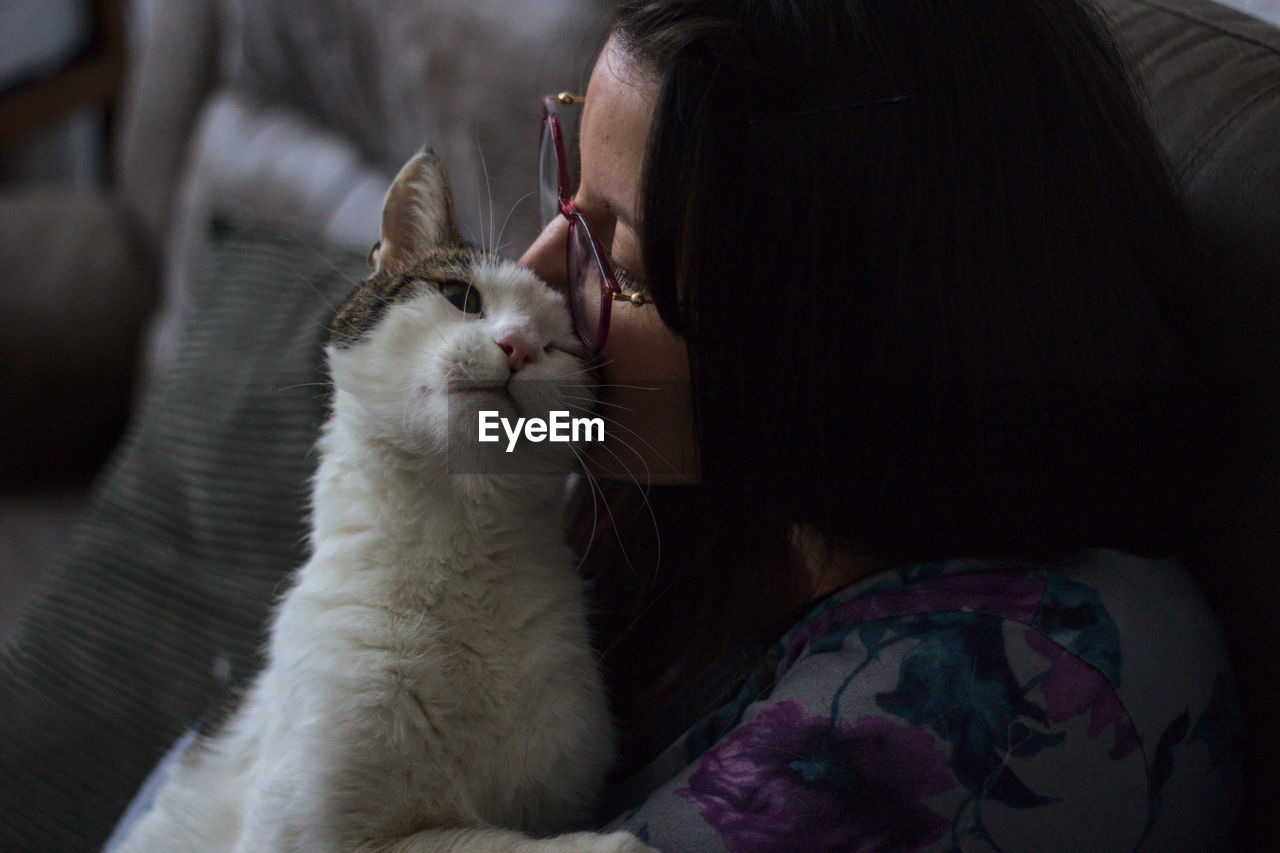 Happy woman with glasses together with her loving cat