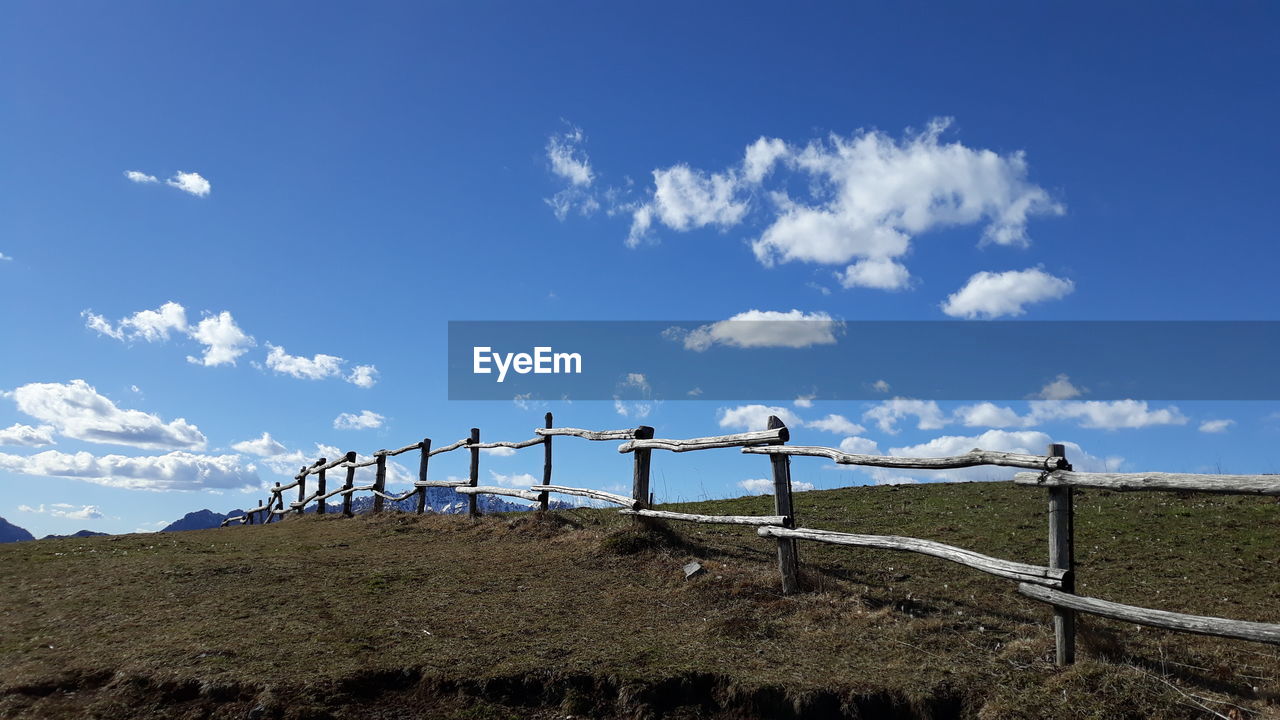 Fence clouds blue sky 