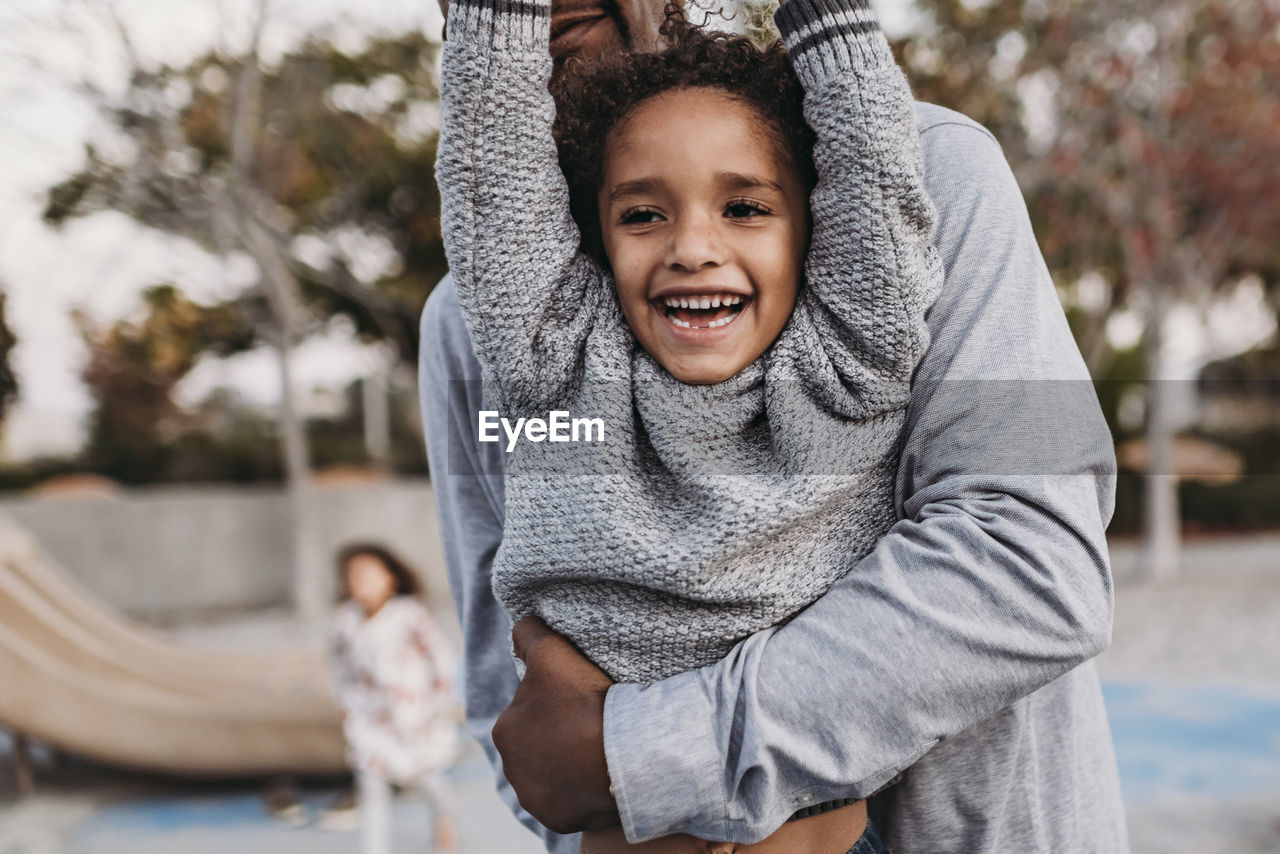 Close up of happy son and father playing on playground at dusk