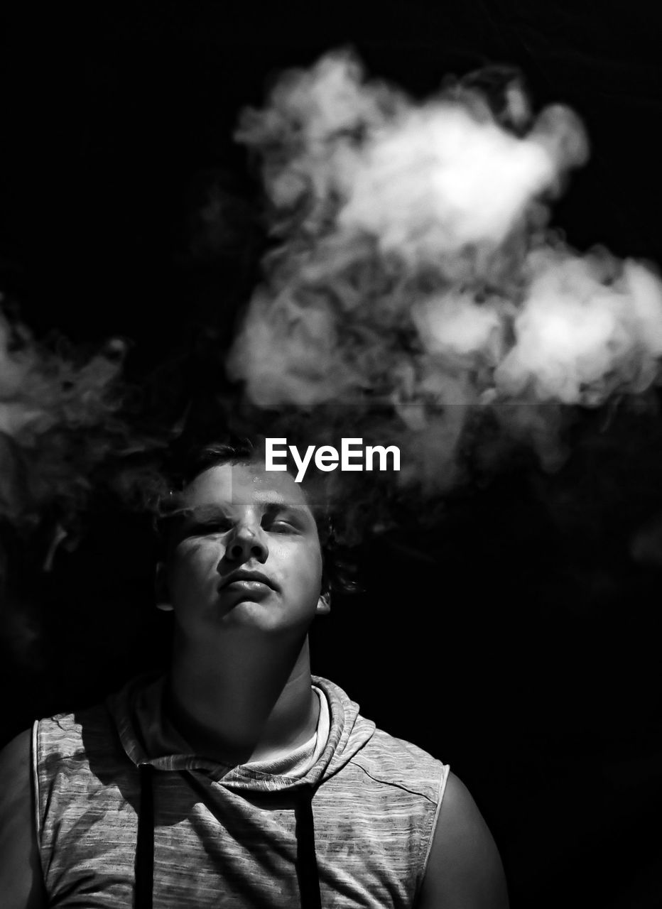 Boy with smokes on a black background 