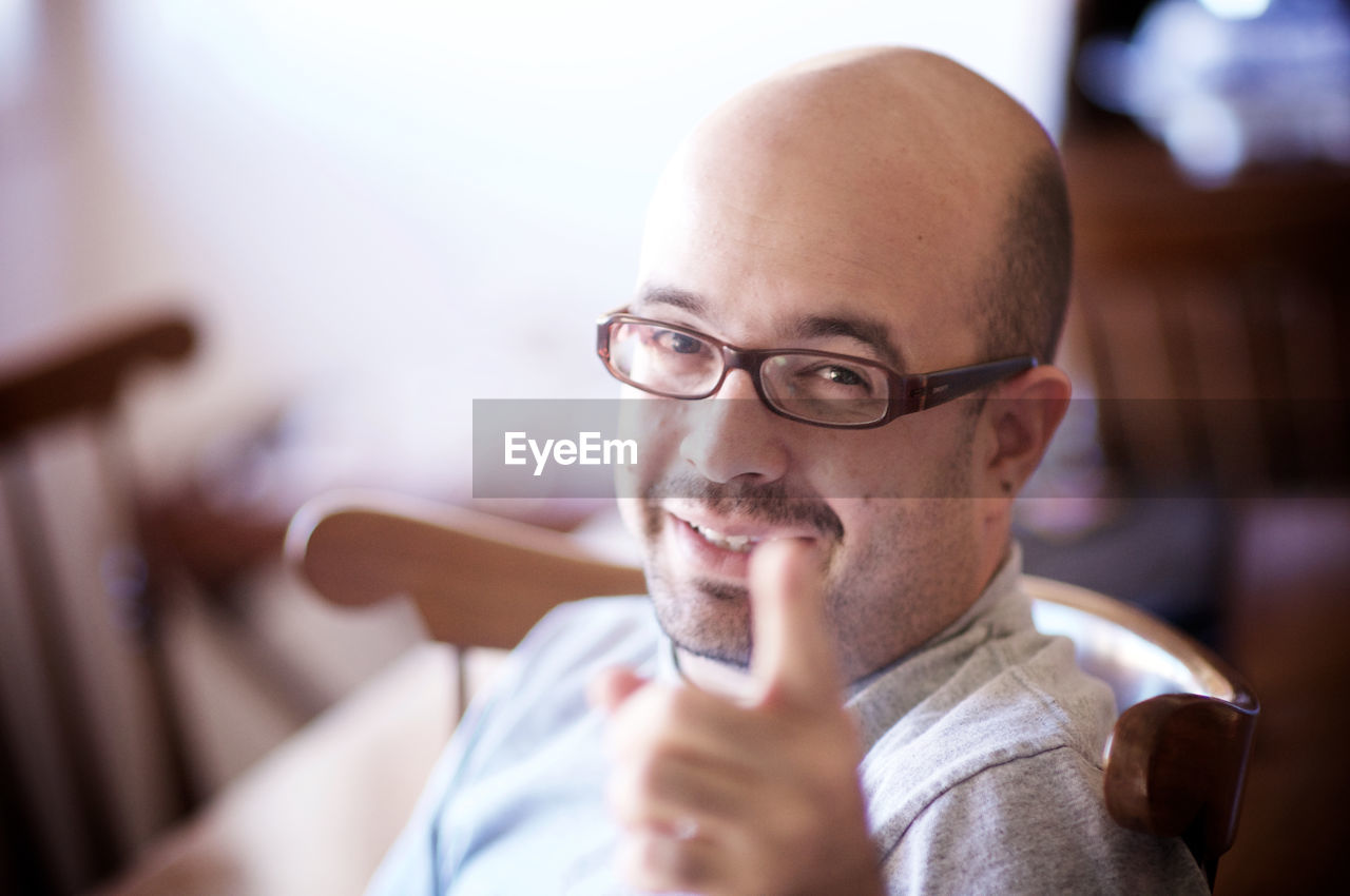 Portrait of man pointing at home