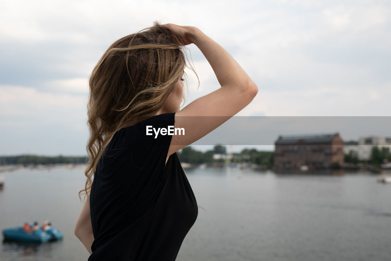 Rear view of woman standing against sky