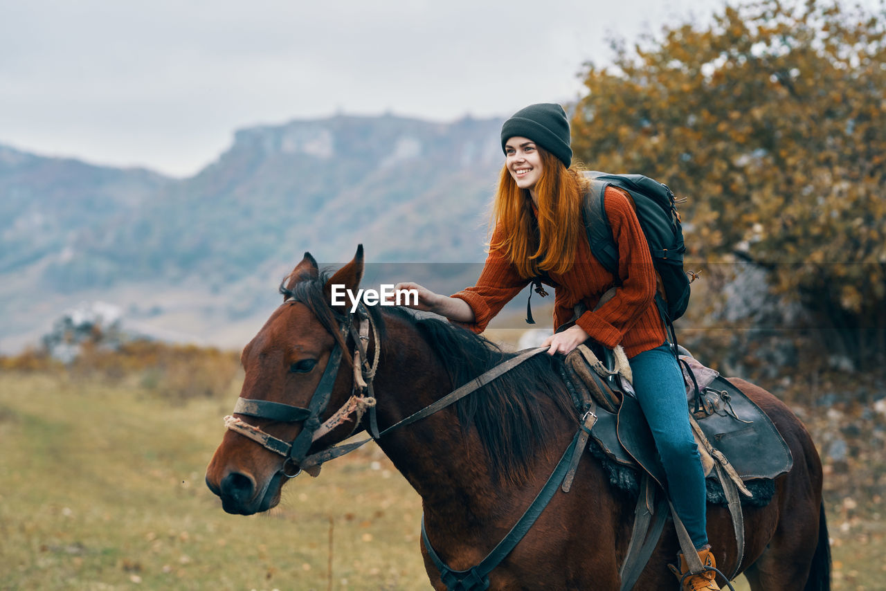 YOUNG WOMAN RIDING HORSE IN A ANIMAL