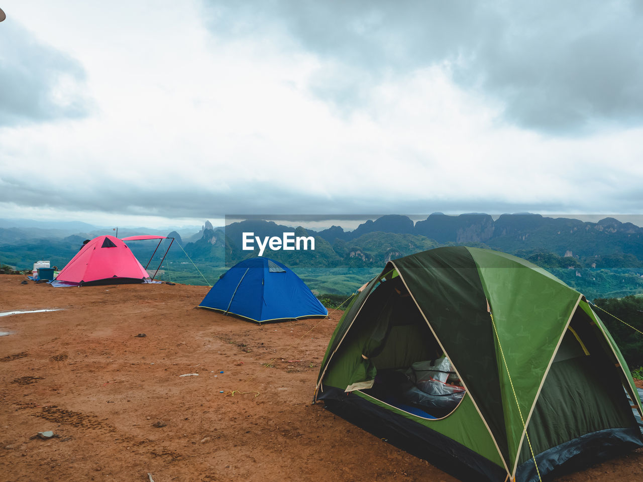 Tourist tent camping on mountains with rain storm and cloudy sky background