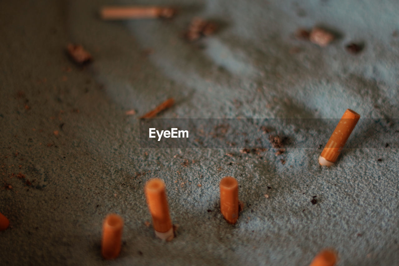 CLOSE-UP OF CIGARETTE ON FLOOR