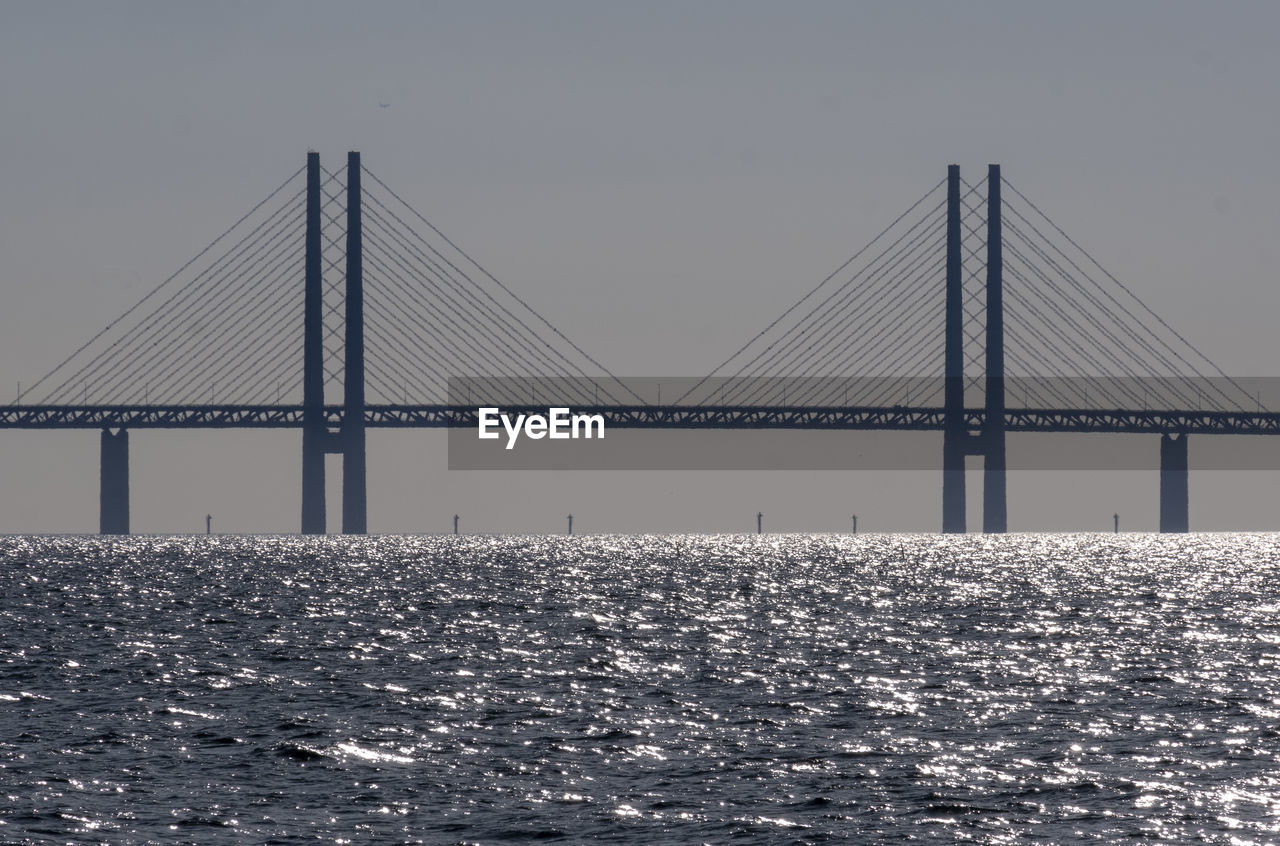 Bridge over sea against clear sky