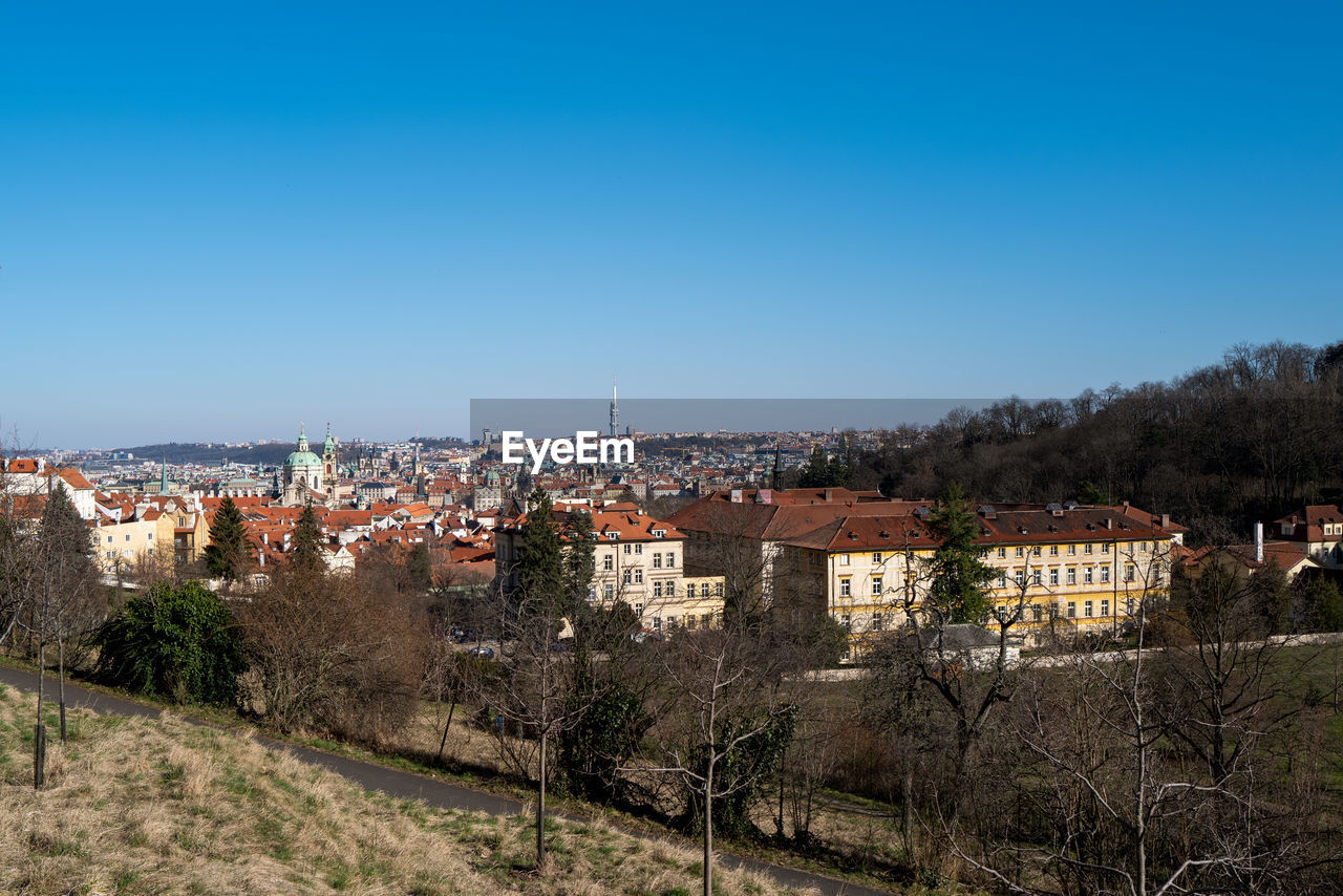 architecture, building exterior, built structure, building, city, sky, town, clear sky, nature, cityscape, residential district, tree, plant, hill, blue, no people, house, copy space, high angle view, travel destinations, landscape, skyline, outdoors, land, urban area, rural area, travel, sunny, day, tourism