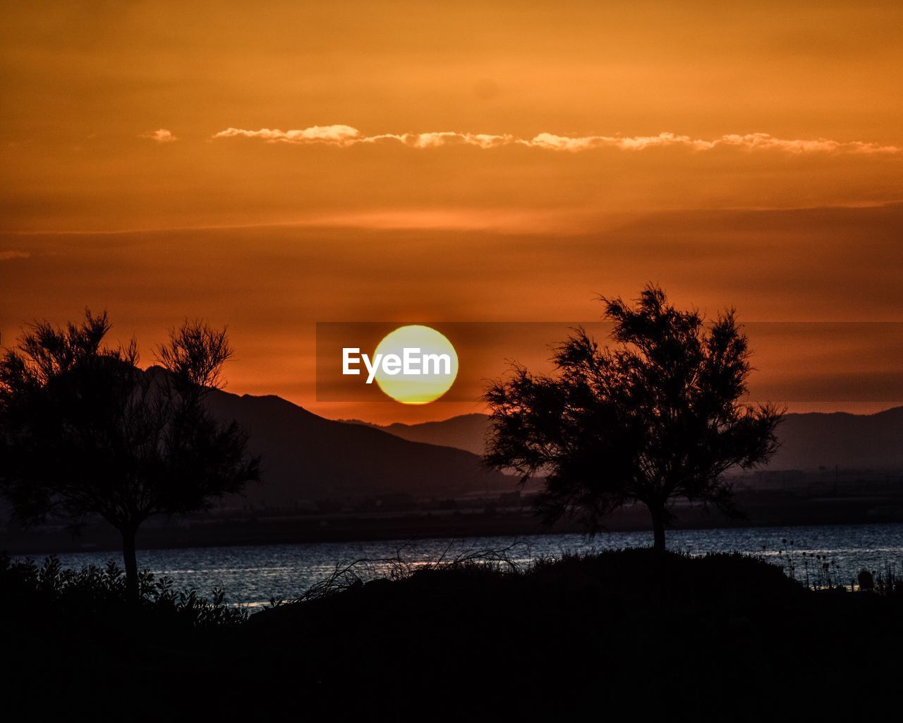 Scenic view of calm lake at sunset