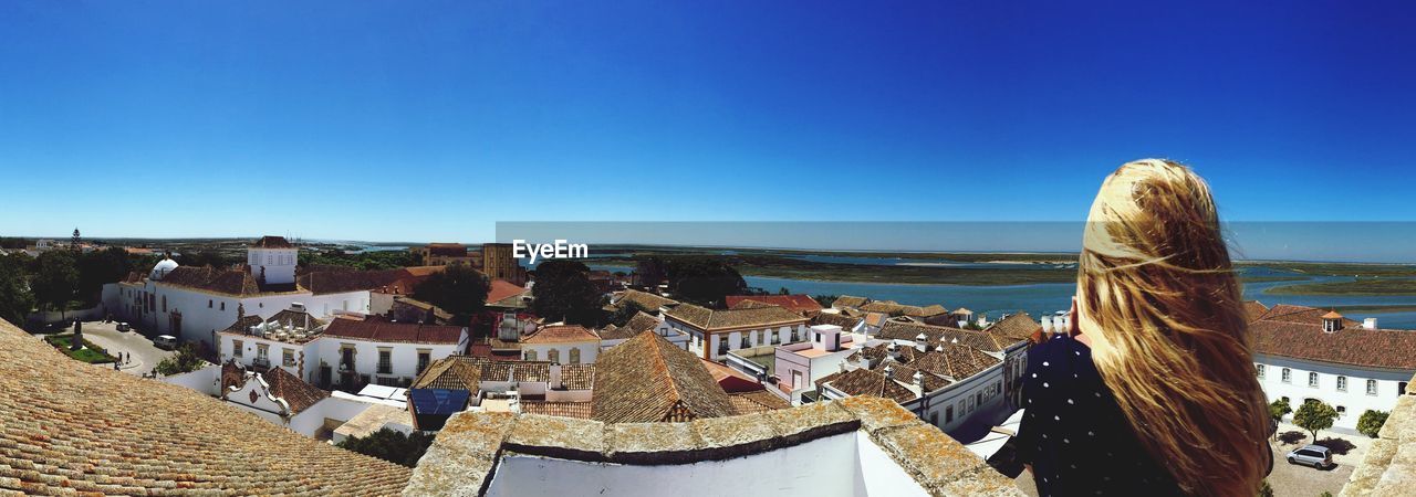 Panoramic view of woman overlooking town