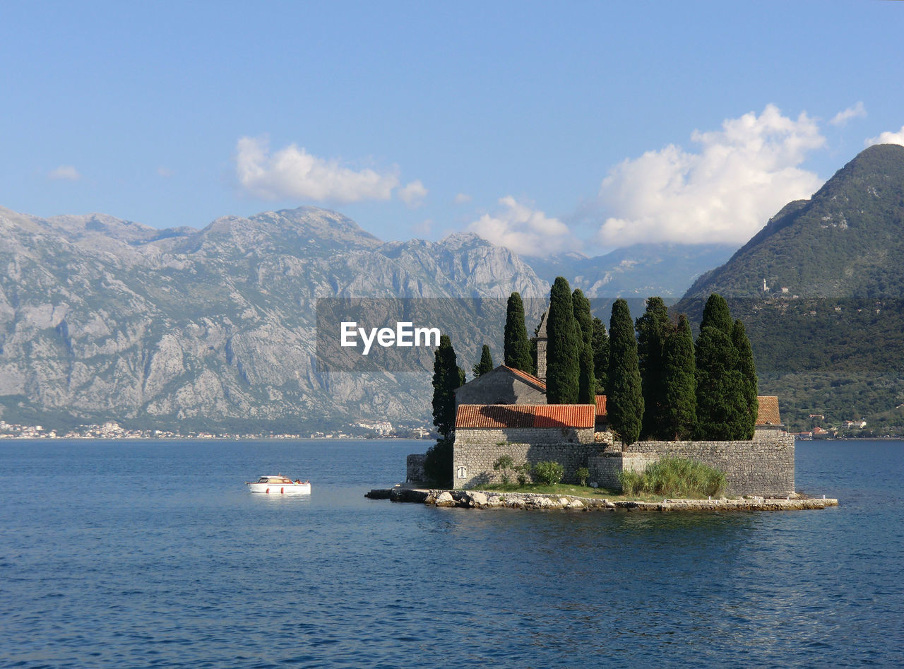 Scenic view of sea by buildings against sky