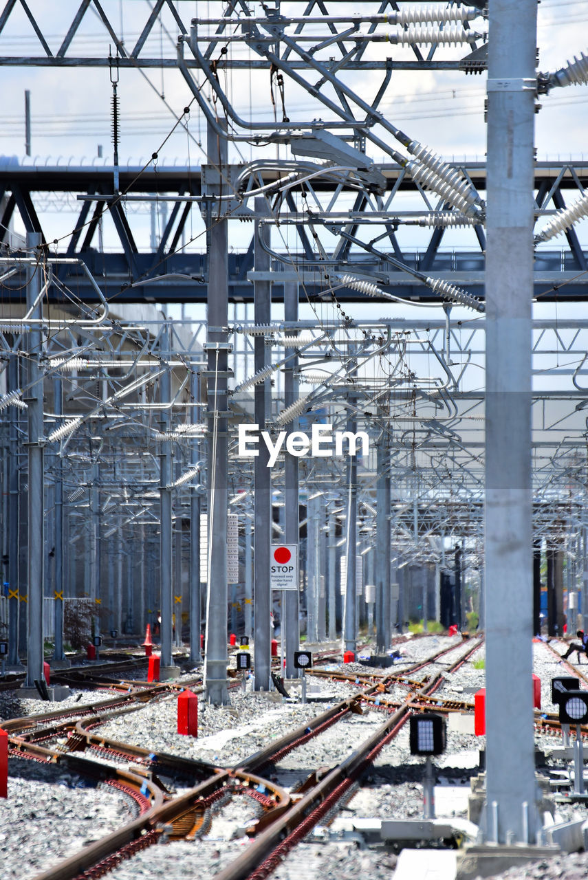 Railroad tracks against electricity pylon