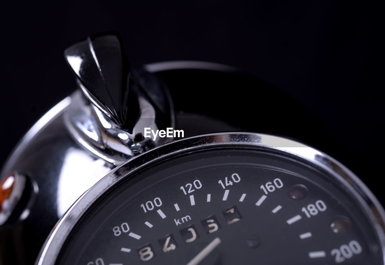 Close-up of motorcycle speedometer against black background