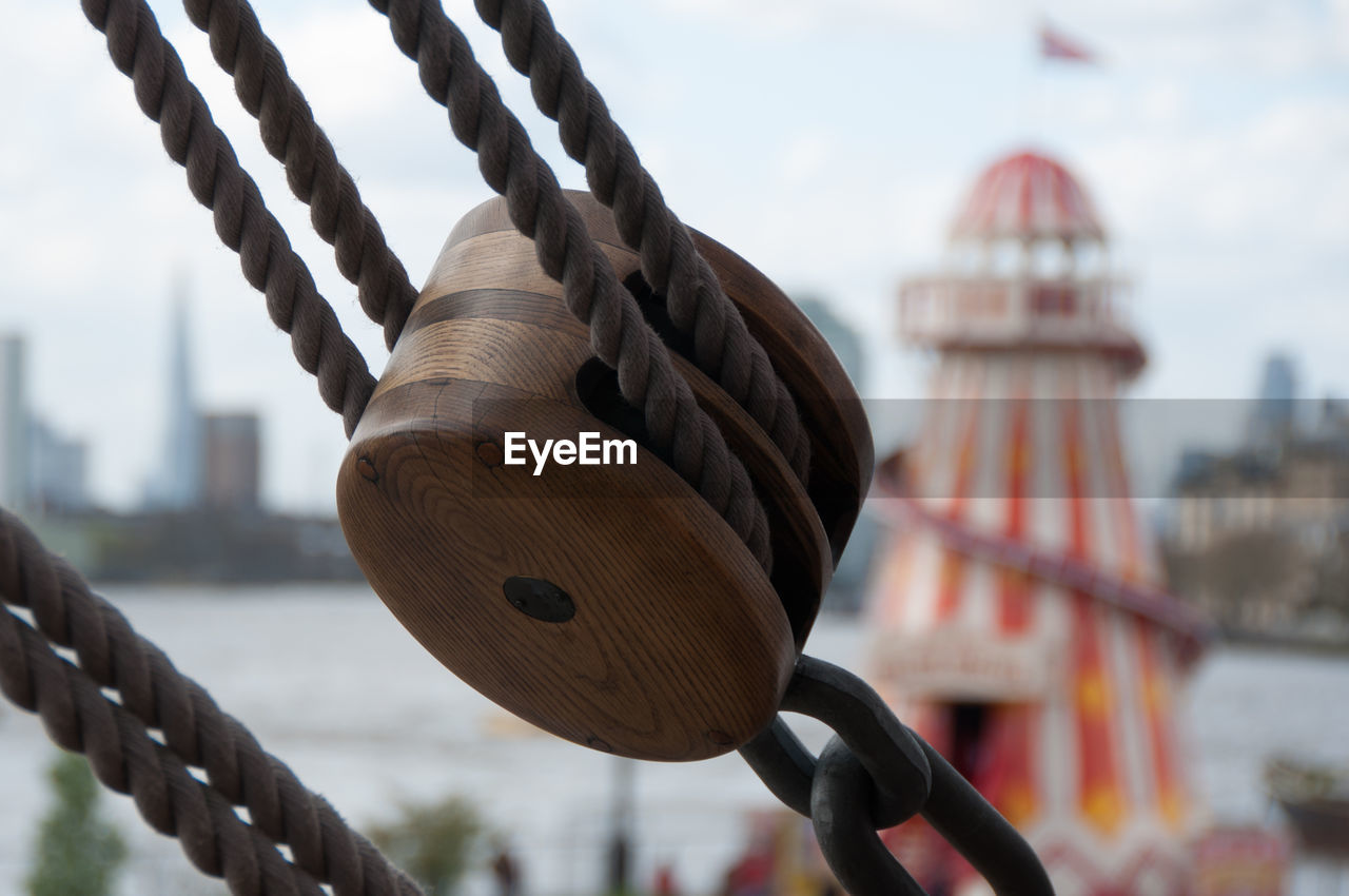 CLOSE-UP OF ROPE HANGING ON BRIDGE