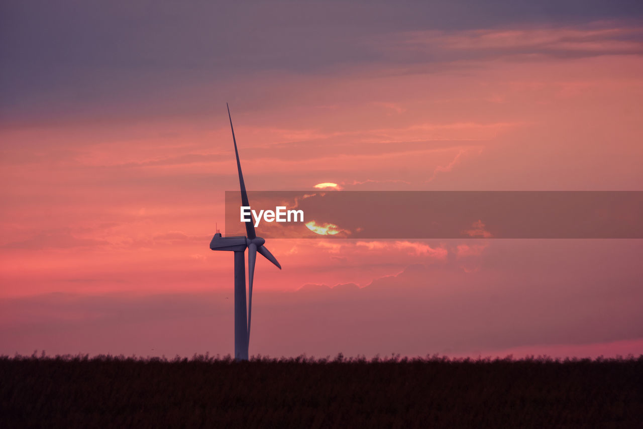 low angle view of windmill against cloudy sky during sunset