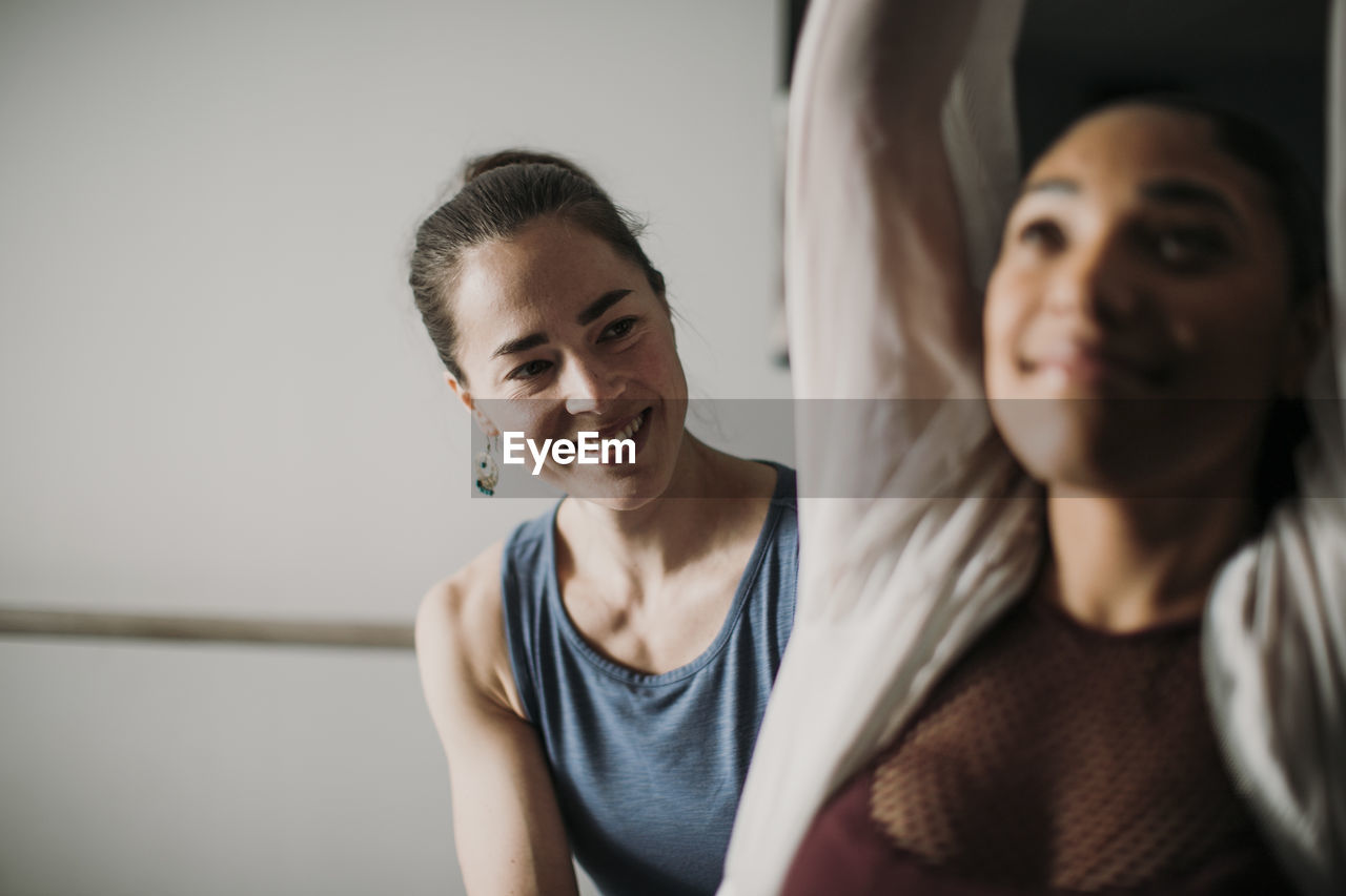 Smiling personal trainer helps her female client with fitness