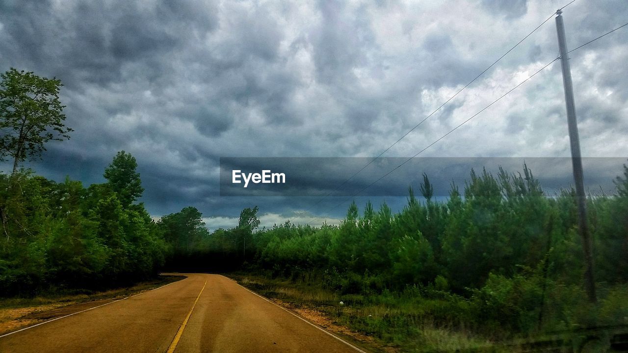 ROAD PASSING THROUGH LANDSCAPE AGAINST CLOUDY SKY