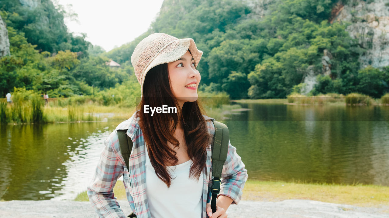 Smiling woman looking away while standing outdoors