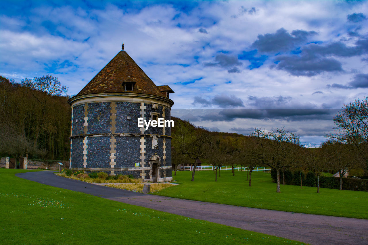 View of lawn against cloudy sky