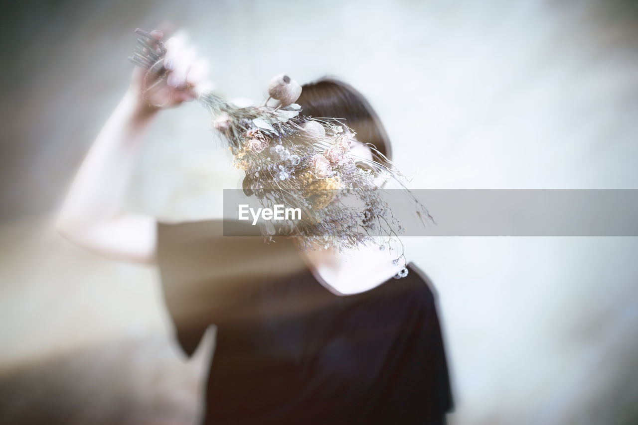 CLOSE-UP OF WOMAN HOLDING FLOWER