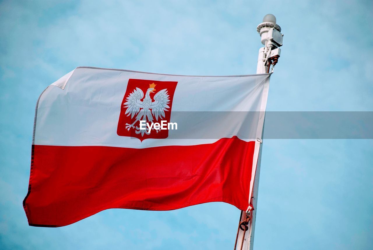 Low angle view of flag against blue sky