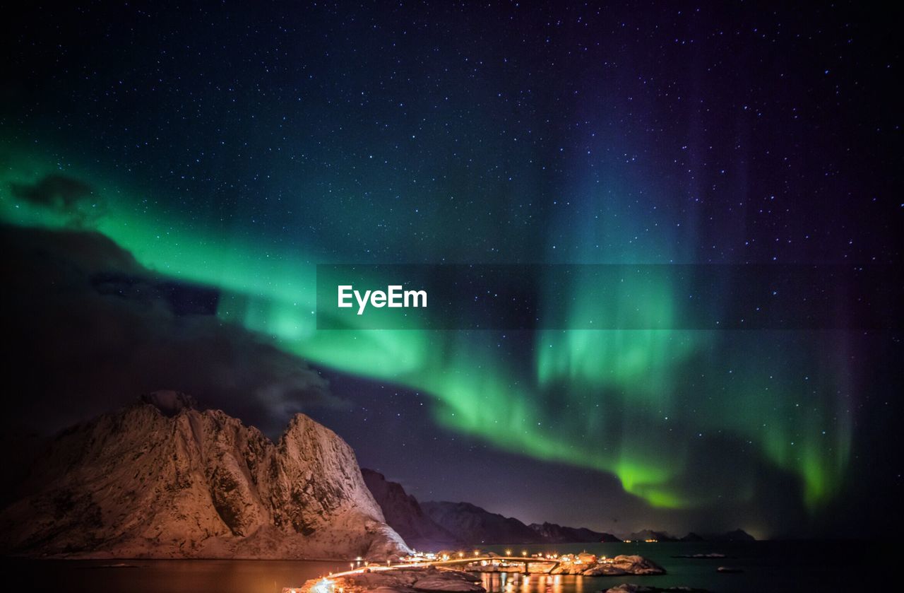 Scenic view of illuminated mountains against sky at night