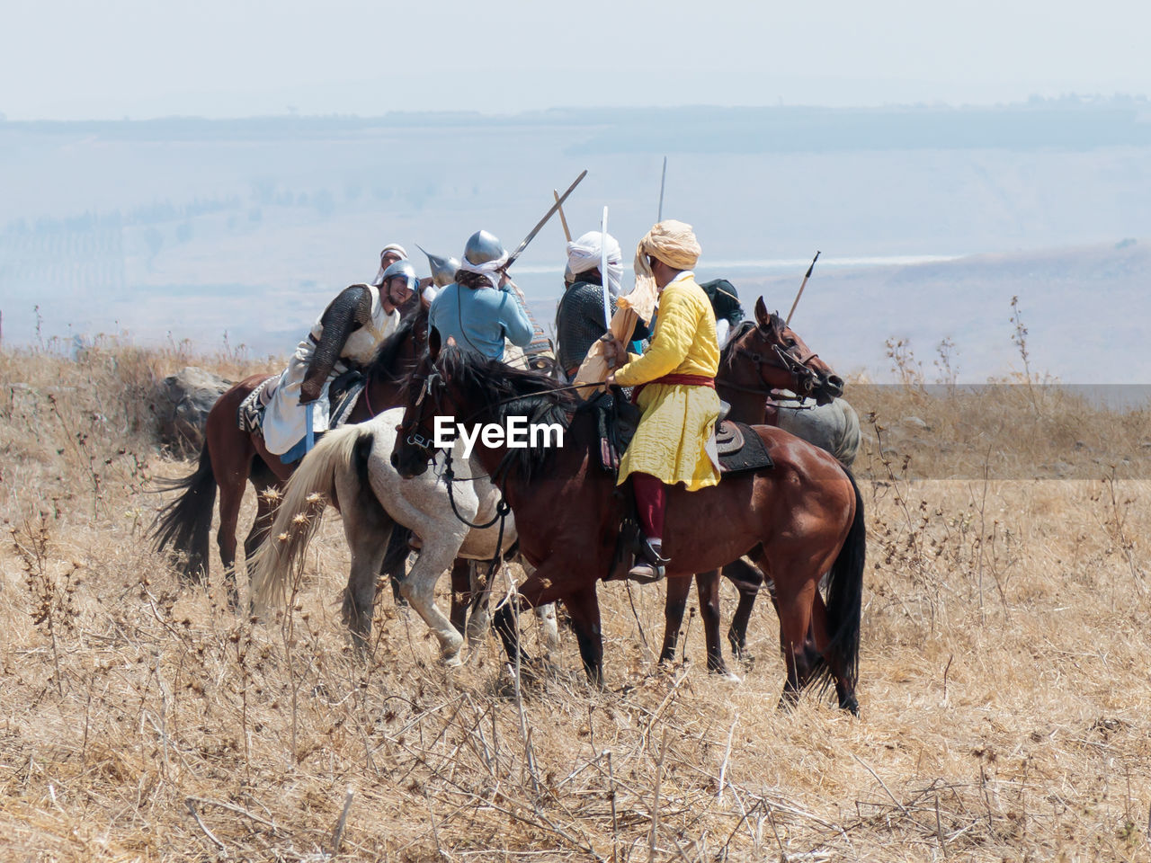 PEOPLE RIDING HORSES ON FIELD