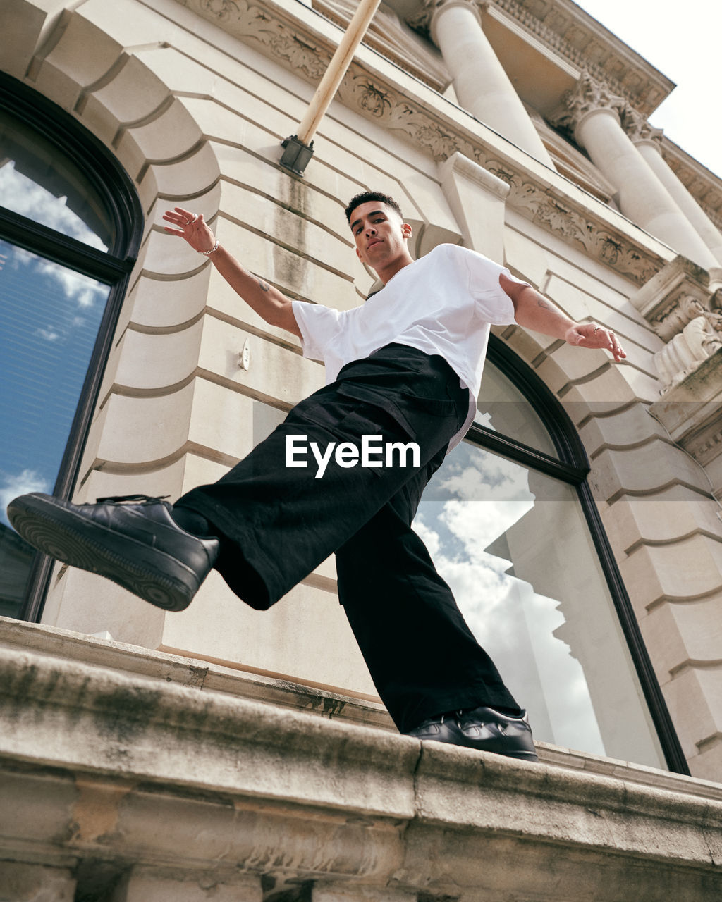 Low angle view of man standing by windows of building