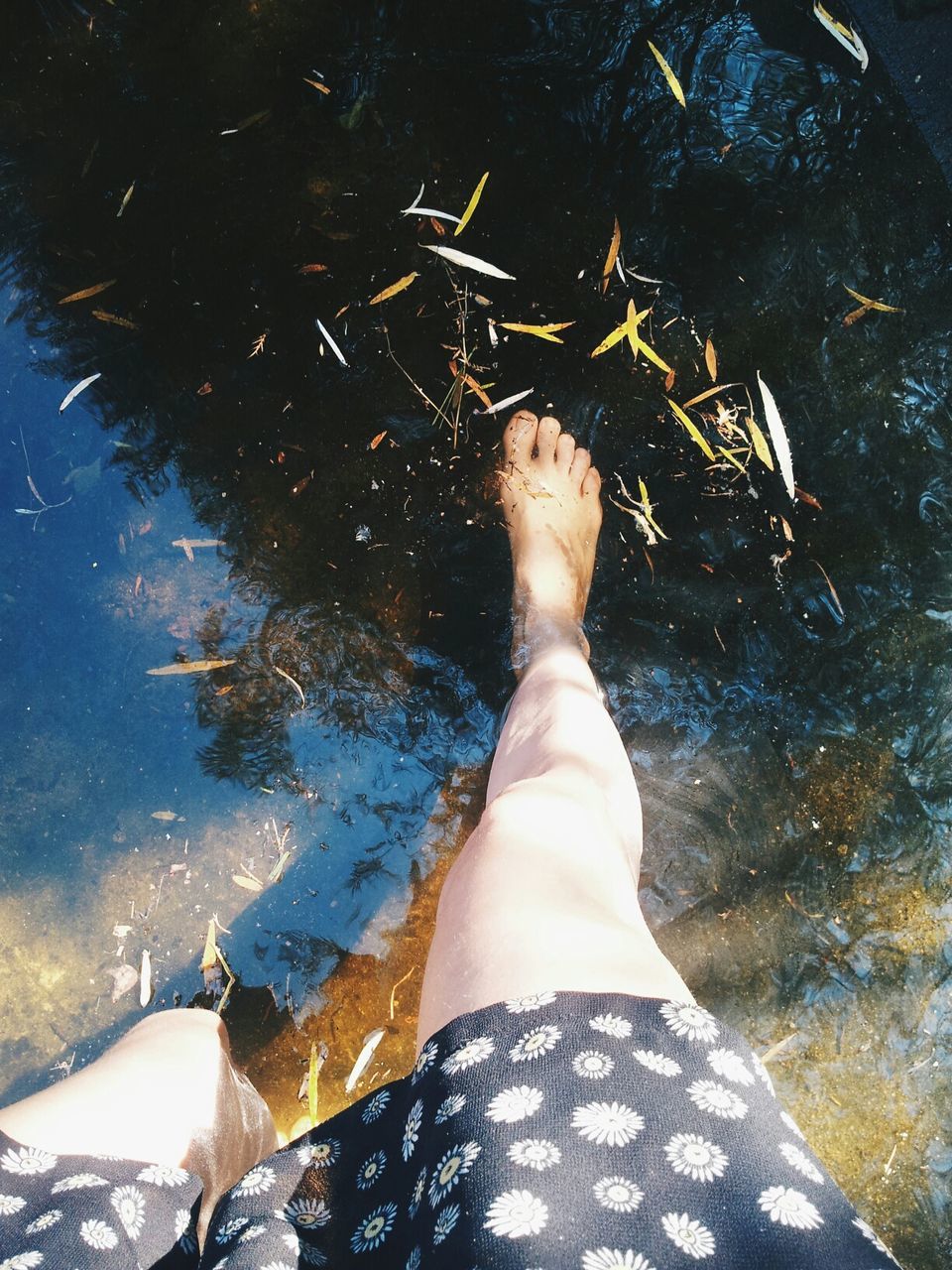 High angle view of woman feet in water